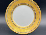 a close up of a yellow and blue plate on a black surface