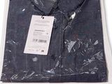 Gros plan sur une chemise dans un sac en plastique posée sur une surface blanche
