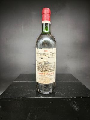 une vieille bouteille de vin posée sur une boîte noire