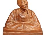 statue d'un homme barbu assis à une table