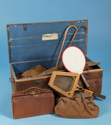 several suitcases and a tennis racquet are sitting on a blue surface