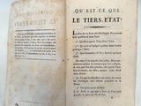 un vieux livre ouvert sur une table, avec une étiquette posée dessus