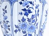 a blue and white vase with flowers on it