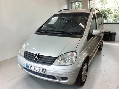 une camionnette argentée garée dans un garage au sol blanc
