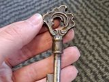 a person holding a small metal key in their hand