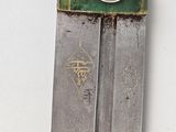 a knife with a green handle on a white surface