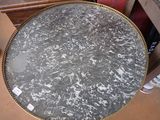 a round table with a marble top on a wooden table
