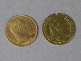 two gold coins sitting next to each other on a table