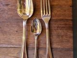 three silver spoons and two silver spoons on a wooden table