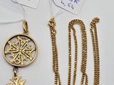 two gold necklaces and a pendant with a bird on it