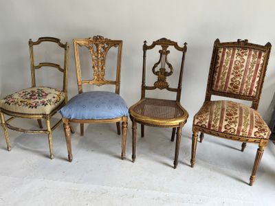 quatre chaises anciennes sont alignées contre un mur dans une pièce