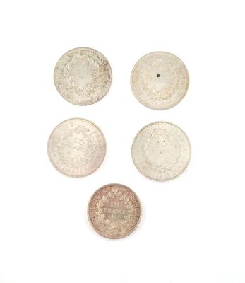 four different types of silver coins on a white surface
