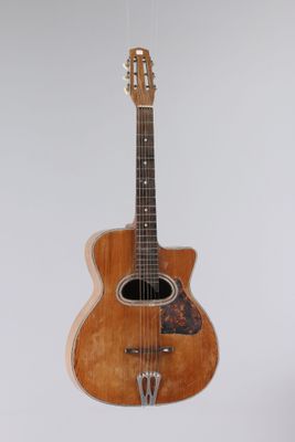 l'image d'une guitare suspendue à une corde sur un mur