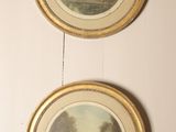 three framed paintings hang on a wall in a room