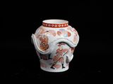 a white vase with a red and orange design on it