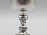 a silver cup on a pedestal on a white background