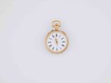 a close up of a gold pocket watch on a white surface