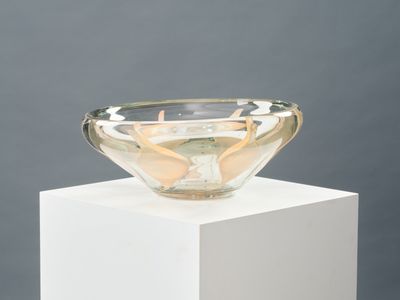 un bol en verre posé sur un socle blanc
