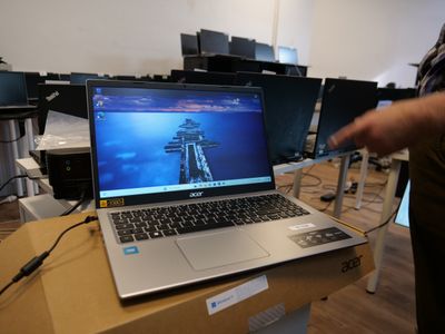 a man standing in front of a laptop on a table