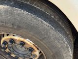 un pneu sale sur le côté d'une voiture blanche