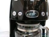 a black coffee maker with a digital clock on it