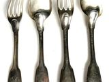 four forks and spoons are lined up on a white surface
