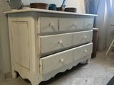 a white dresser in a room with a mirror on the wall