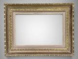 an empty gold frame hanging on a gray wall