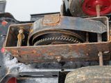 a close up of a small machine with a red wheel