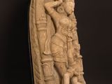 a statue of a woman holding a child on a wooden table