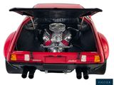 a red car with an engine in the trunk of it