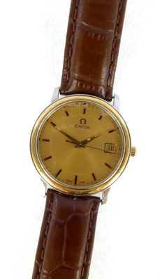 a close up of a watch on a white surface with a brown strap