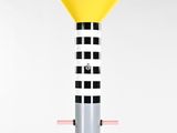 a close up of a yellow and black lamp on a pole