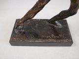 bronze statue of a man holding a tennis racquet on a marble base