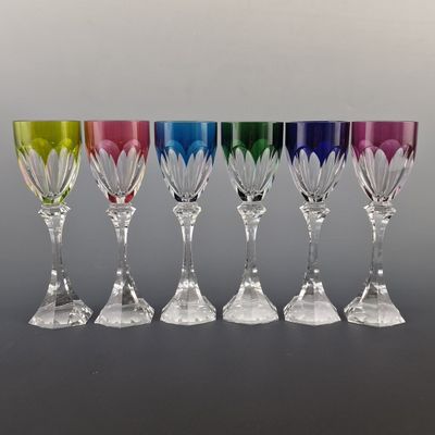 six different colored wine glasses are lined up in a row