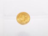 a close up of a gold coin on a white surface