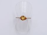 a close up of a ring with a yellow stone on it