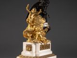 a gold and white statue of a man on a horse on a pedestal
