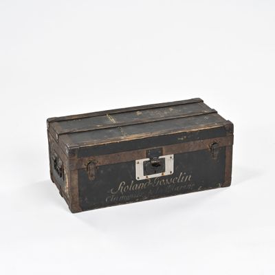 une vieille valise posée sur une surface blanche