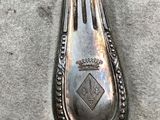 a silver spoon with a crown on it sitting on a table
