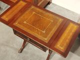 a wooden table with a leather top and a drawer underneath it