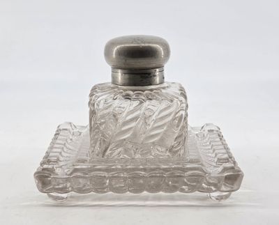 a clear glass bottle with a silver lid on a tray