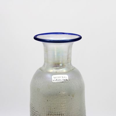 un vase en verre à bord bleu posé sur une table