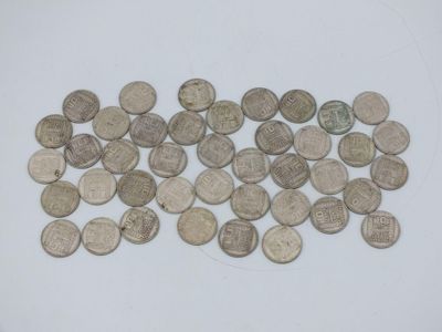 a pile of silver coins on a white surface