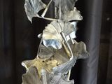 a metal sculpture of a plant with leaves on it