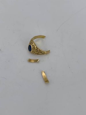 a close up of a gold ring with a blue stone
