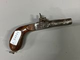 un vieux pistolet muni d'une étiquette, accroché au mur