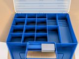 a blue plastic box with compartments on it on a cardboard box
