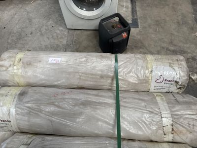 une pile de rouleaux de papier toilette à côté d'une machine à laver