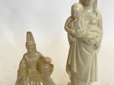deux figurines représentant une femme tenant un bébé dans ses bras
